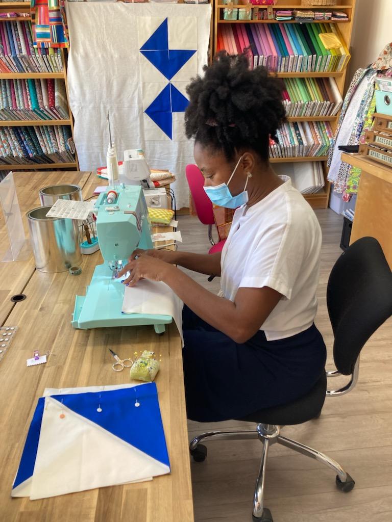 a brown skinned girl at a sewing machine